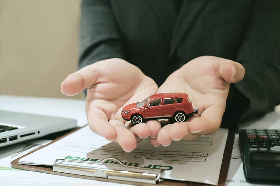 man holding a red toy car